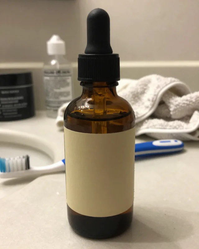 Before: a phone snapshot of a serum bottle on a cluttered bathroom counter